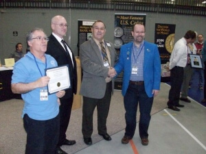 man with an award beside a group