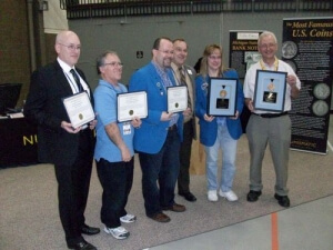 group of people, all with awards